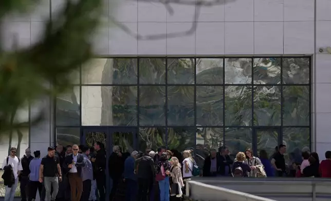 People gather outside a courthouse after a gunman opened fire leaving several people wounded in Athens, Tuesday, April 28, 2026. (AP Photo/Petros Giannakouris)