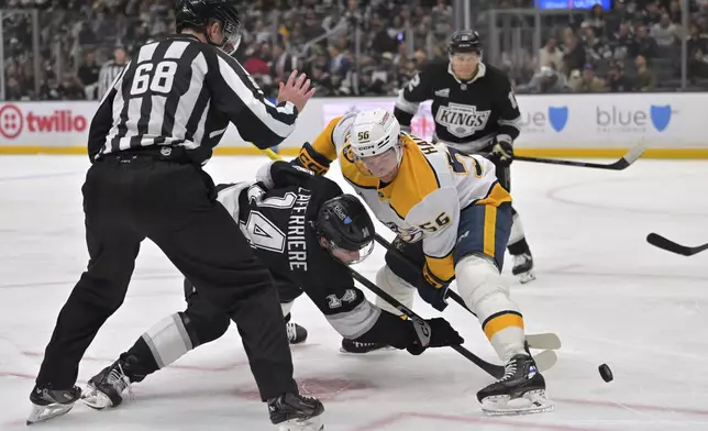 Linesman CJ Murray (68) drops the puck as Los Angeles Kings right wing Alex Laferriere (14) and Nashville Predators left wing Erik Haula face off during the second period of an NHL hockey game Thursday, April 2, 2026, in Los Angeles. (AP Photo/Jayne Kamin-Oncea)
