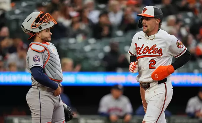 Baltimore Orioles Gunnar Henderson (2) scores past Houston Astros catcher Yainer Diaz, left, on an RBI hit by Orioles' Adley Rutschman during the first inning of a baseball game, Tuesday, April 28, 2026, in Baltimore. (AP Photo/Stephanie Scarbrough)