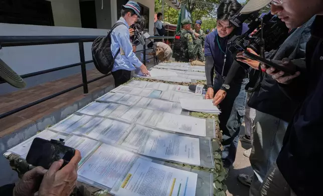 Journalist review scam scripts in Surin, Thailand, Tuesday, April 7, 2026. (AP Photo/Sakchai Lalit)