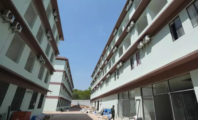 A Thai soldier guards outside the scam compound in O'Smach, Cambodia, Tuesday, April 7, 2026. (AP Photo/Sakchai Lalit)