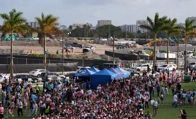 Fans wait in line to enter Nu Stadium, as signs of ongoing work are seen behind, ahead of the team's first MLS soccer match in their new stadium, against Austin FC, Saturday, April 4, 2026, in Miami. (AP Photo/Rebecca Blackwell)