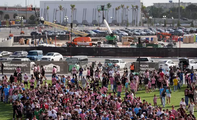 Fans wait in line to enter Nu Stadium, as signs of ongoing work are seen behind, ahead of the team's first MLS soccer match in their new stadium, against Austin FC, Saturday, April 4, 2026, in Miami. (AP Photo/Rebecca Blackwell)