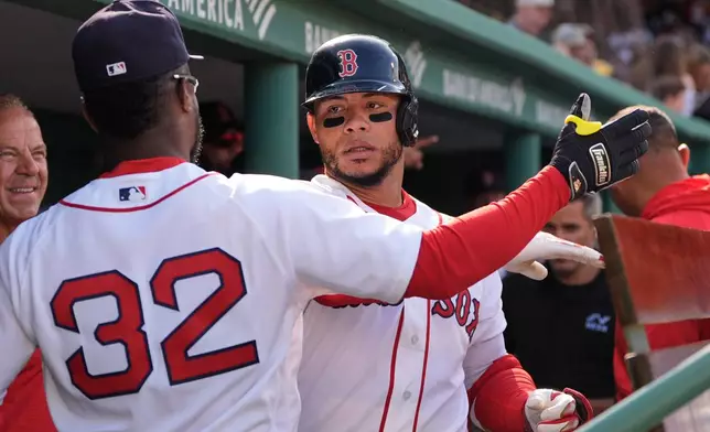 Boston Red Sox's Willson Contreras, right, celebrates with Andruw Monasterio (32) after hitting a solo home run against the San Diego Padres during the sixth inning on a home-opener baseball game at Fenway Park, Friday, April 3, 2026, in Boston. (AP Photo/Charles Krupa)