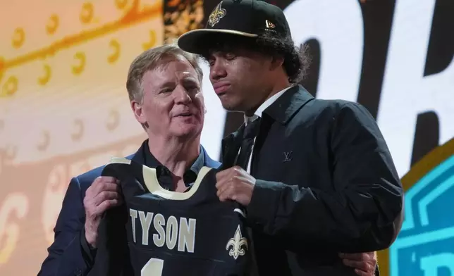 Arizona State wide receiver Jordyn Tyson cries while standing with NFL Commissioner Roger Goodell after being chosen by the New Orleans Saints with the eighth overall pick during the first round of the NFL football draft, Thursday, April 23, 2026, in Pittsburgh. (AP Photo/Gene J. Puskar)