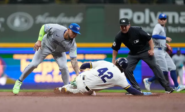 Toronto Blue Jays' Lenyn Sosa, left, tags out Milwaukee Brewers' Brice Turang at second base during the sixth inning of a baseball game Wednesday, April 15, 2026, in Milwaukee. (AP Photo/Aaron Gash)