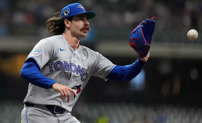 Toronto Blue Jays' Dylan Cease catches the ball at first base to force an out during the second inning of a baseball game against the Milwaukee Brewers, Wednesday, April 15, 2026, in Milwaukee. (AP Photo/Aaron Gash)