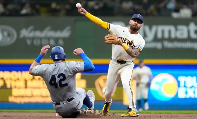 Milwaukee Brewers' Joey Ortiz, right, throws to first base to turn a double play after tagging Toronto Blue Jays' Brandon Valenzuela, left, out at second during the third inning of a baseball game Wednesday, April 15, 2026, in Milwaukee. (AP Photo/Aaron Gash)