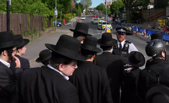 Members of the community watch as forensic officers search the area after two people were stabbed in the Golders Green neighbourhood, that has a large Jewish community, in London, Wednesday, April 29, 2026.(AP Photo/Kin Cheung)