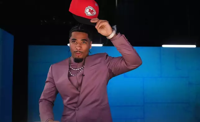LSU defensive back Mansoor Delane puts on a hat after being chosen by the Kansas City Chiefs with the sixth overall pick during the first round of the NFL football draft, Thursday, April 23, 2026, in Pittsburgh. (AP Photo/Jeff Roberson)