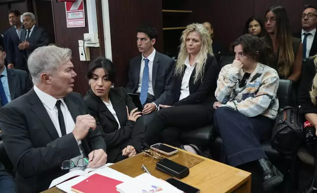 Dalma Maradona, right, and Gianinna Maradona, second left, daughters of late soccer star Diego Maradona attend the first day of the trial over allegations of homicide by negligence against the medical team that treated their father in San Isidro, Argentina, Tuesday, April 14, 2026. (AP Photo/Rodrigo Abd)
