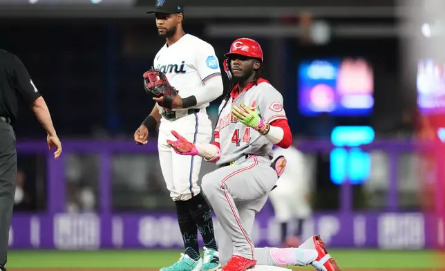 Cincinnati Reds shortstop Elly de la Cruz, right, reacts after hitting a double during the fourth inning of a baseball game against the Miami Marlins, Monday, April 6, 2026, in Miami. (AP Photo/Lynne Sladky)