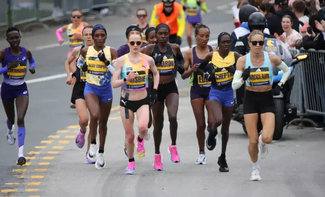 Jess McClain, right, runs in the lead pack on the Boston Marathon course in Newton, Mass., on Monday, April 20, 2026. (AP Photo/Jennifer McDermott)