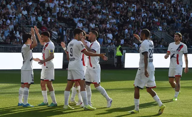 PSG's Lee Kang-in, left, celebrates with his teammates after scoring during the French League One soccer match between Angers and Paris Saint-Germain in Angers, western France, Saturday, April 25, 2026. (AP Photo/Mathieu Pattier)