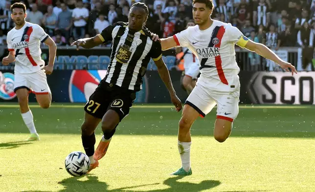 Angers' Lilian Raolisoa, left, challenges for the ball with PSG's Achraf Hakimi, right, during the French League One soccer match between Angers and Paris Saint-Germain in Angers, western France, Saturday, April 25, 2026. (AP Photo/Mathieu Pattier)