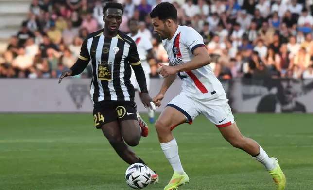 PSG's Goncalo Ramos, right, challenges for the ball with Angers' Emmanuel Biumla, left, during the French League One soccer match between Angers and Paris Saint-Germain in Angers, western France, Saturday, April 25, 2026. (AP Photo/Mathieu Pattier)