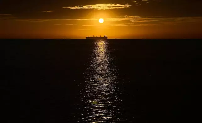 An oil vessel is visible in the Caribbean Sea at sunset during a nearby conference aimed at transitioning away from fossil fuels Tuesday, April 28, 2026, in Santa Marta, Colombia. (AP Photo/Ivan Valencia)