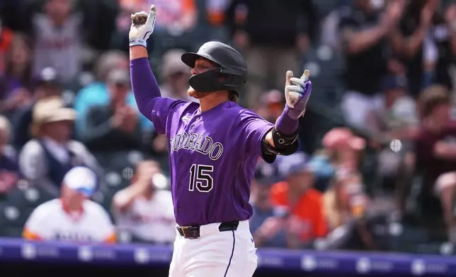 Colorado Rockies' Hunter Goodman celebrates as he crosses home plate after hitting a solo home run off Houston Astros relief pitcher Enyel de Los Santos in the fourth inning of a baseball game Wednesday, April 8, 2026, in Denver. (AP Photo/David Zalubowski)