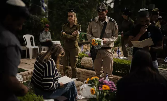 People visit the graves of their relatives as they mark Israel's annual Memorial Day, honoring soldiers killed in the nation's conflicts and victims of nationalistic attacks, at Mount Herzl military cemetery in Jerusalem, Tuesday, April 21, 2026. (AP Photo/Leo Correa)