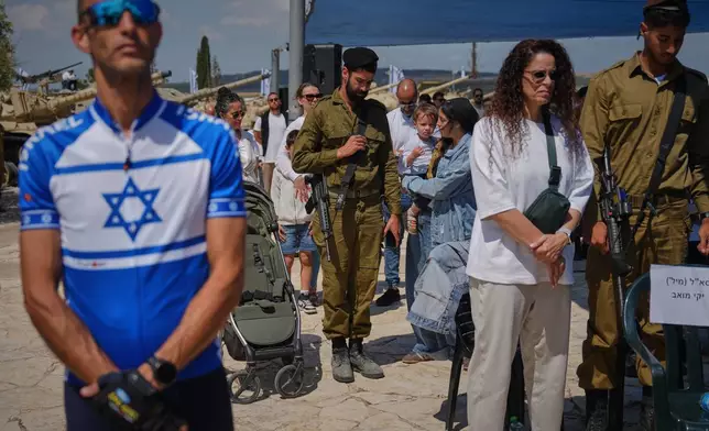Israelis observe two minutes of silence as air raid sirens sound to mark Memorial Day for soldiers who died in the nation's conflicts and victims of nationalistic attacks at the Armored Corps memorial site in Latrun, Israel Tuesday, April 21, 2026. (AP Photo/Ariel Schalit)