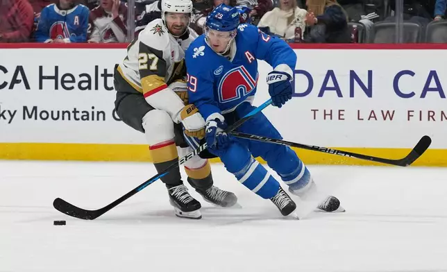 Colorado Avalanche center Nathan MacKinnon, right, drives past Vegas Golden Knights defenseman Shea Theodore, left, in the third period of an NHL hockey game Saturday, April 11, 2026, in Denver. (AP Photo/David Zalubowski)