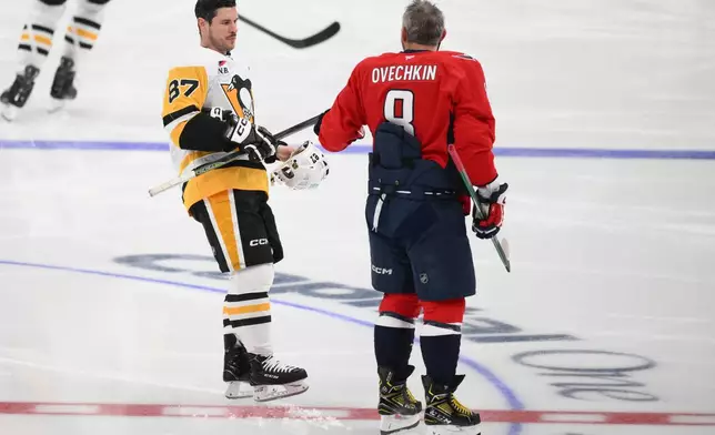 Pittsburgh Penguins center Sidney Crosby (87) meets with Washington Capitals left wing Alex Ovechkin (8) during warmups before an NHL hockey game, Sunday, April 12, 2026, in Washington. (AP Photo/Nick Wass)
