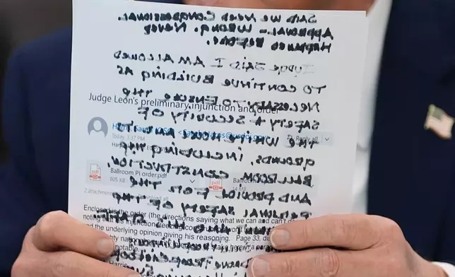 FILE - President Donald Trump holds papers in the Oval Office of the White House before signing an executive orde, March 31, 2026, in Washington. (AP Photo/Alex Brandon, File)