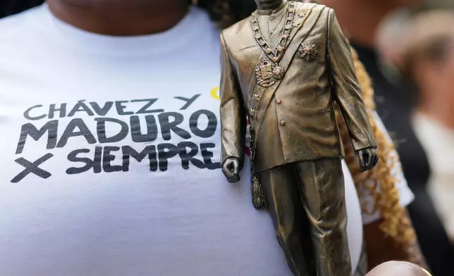 FILE - A woman holds a statuette of former Venezuelan President Nicolas Maduro at a government-organized event to watch Maduro and his wife, Cilia Flores, appear in a New York court on a screen in Caracas, Venezuela, March 26, 2026. (AP Photo/Ariana Cubillos, File)