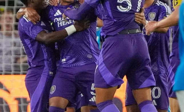 Orlando City SC midfielder Luis Otavio, second from left, celebrates a goal against Charlotte FC with teammates including defender Iago Teodoro da Silva Nogueira (57) during the first half of an MLS soccer match, Wednesday, April 22, 2026, in Orlando, Fla. (AP Photo/John Raoux)