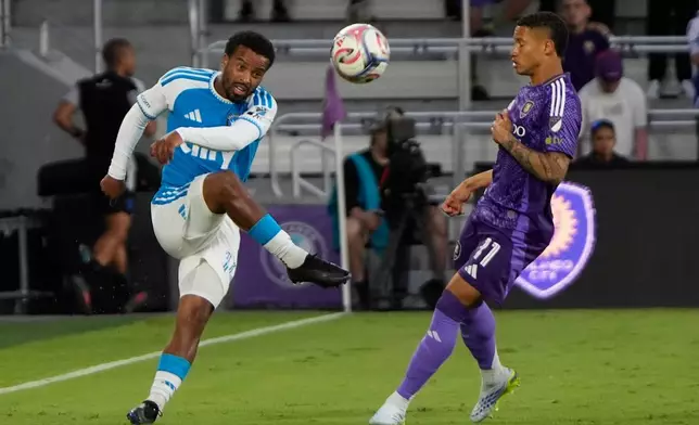 Charlotte FC defender Nathan Byrne, left, passes the ball over Orlando City SC midfielder Tiago during the first half of an MLS soccer match, Wednesday, April 22, 2026, in Orlando, Fla. (AP Photo/John Raoux)