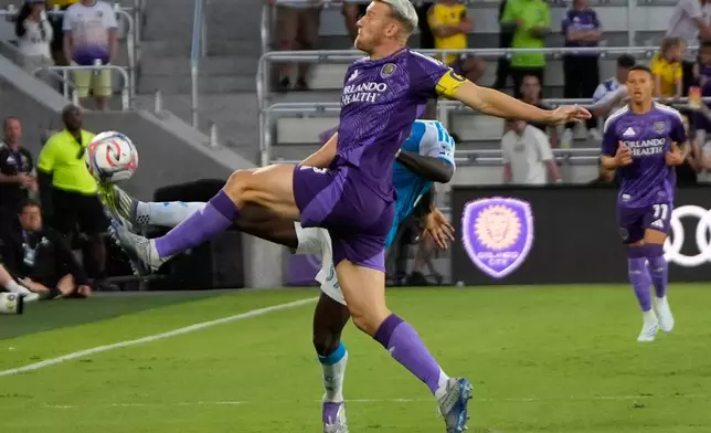 Orlando City SC defender Robin Jansson, front, tries to control the ball in front of Charlotte FC forward Rodolfo Aloko during the first half of an MLS soccer match, Wednesday, April 22, 2026, in Orlando, Fla. (AP Photo/John Raoux)