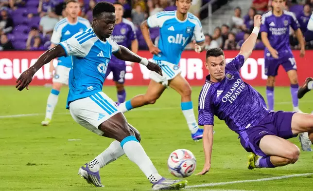 Charlotte FC forward Rodolfo Aloko, left, attempts a shot on goal as Orlando City SC defender Adrian Marin, right, tries to block during the first half of an MLS soccer match, Wednesday, April 22, 2026, in Orlando, Fla. (AP Photo/John Raoux)