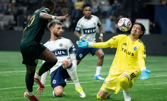 Portland Timbers' David da Costa (10) scores on Vancouver Whitecaps goalkeeper Yohei Takaoka (1) as Tristan Blackmon (33) watches during the first half of an MLS soccer match in Vancouver, British Columbia, on Saturday, April 4, 2026. (Ethan Cairns/The Canadian Press via AP)