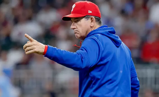 Philadelphia Phillies manager Rob Thomson signals to change pitchers against the Atlanta Braves during the seventh inning of a baseball game, Saturday, April 25, 2026, in Atlanta. (AP Photo/Erik S. Lesser)