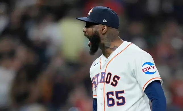 Houston Astros pitcher Enyel de Los Santos (65) yells after a strikeout to earn the save during the ninth inning of a baseball game against the Colorado Rockies, Tuesday, April 14, 2026, in Houston. (AP Photo/Kevin M. Cox)