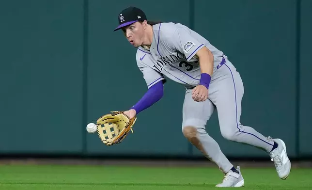 Colorado Rockies center fielder Jake McCarthy (31) fields a single by Houston Astros' Christian Walker during the seventh inning of a baseball game Tuesday, April 14, 2026, in Houston. (AP Photo/Kevin M. Cox)