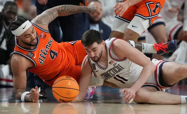 UConn's Alex Karaban (11) and Illinois' Kylan Boswell (4) dive after a loose ball during the first half of an NCAA college basketball tournament semifinal game at the Final Four, Saturday, April 4, 2026, in Indianapolis. (AP Photo/Michael Conroy)