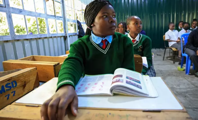 Everlyne Nasenya,16, left, and Valarie Wairimu, 19, both teen mothers are seen in a classroom at Greenland Girls School in Kajiado, Kenya, March 5, 2026. (AP Photo/Andrew Kasuku)