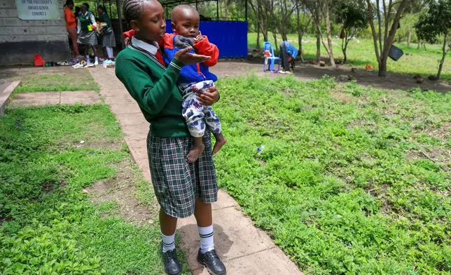 Valarie Wairimu, 19, interacts with her son, Kayden Darmain during breaktime at Greenland Girls School in Kiserian, Kajiado, Kenya, March 5, 2026. (AP Photo/Andrew Kasuku)