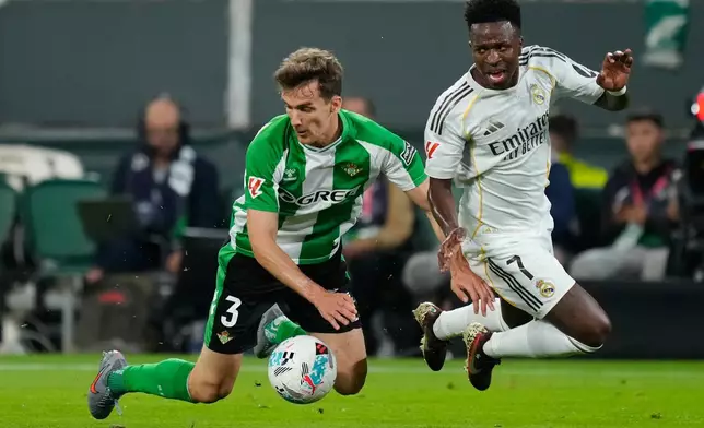 Betis' Diego Llorente , left, and Real Madrid's Vinicius Junior fight for the ball during a La Liga soccer match between Real Betis and Real Madrid in Seville, Spain, Friday, April 24, 2026. (AP Photo/Jose Breton)
