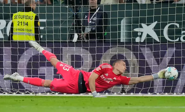Real Madrid's goalkeeper Andriy Lunin saves during a La Liga soccer match between Real Betis and Real Madrid in Seville, Spain, Friday, April 24, 2026. (AP Photo/Jose Breton)