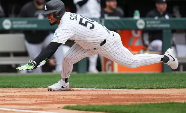 Chicago White Sox designated hitter Lenyn Sosa (50) dives home to score on a sacrifice fly by Munetaka Murakami during the first inning of a baseball game against the Toronto Blue Jays, Saturday, April 4, 2026, in Chicago. (AP Photo/Erin Hooley)