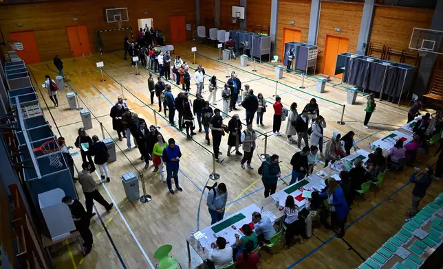 People queue up at a polling station during the Hungarian parliamentary election in Budapest, Hungary, Sunday, April 12, 2026. (AP Photo/Denes Erdos)