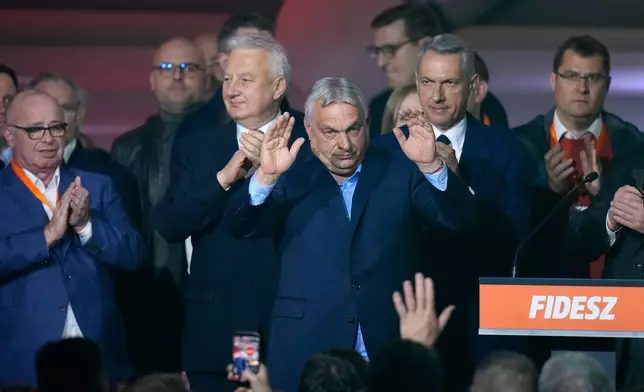 Hungary's Prime Minister Viktor Orban, center, flanked by his team reacts after a parliamentary election in Budapest, Hungary, Sunday, April 12, 2026. (AP Photo/Petr David Josek)