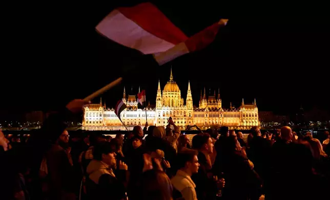 People react in the streets after the announcement of partial results of the Hungarian parliamentary election in Budapest, Hungary, Sunday, April 12, 2026. (AP Photo/Denes Erdos)