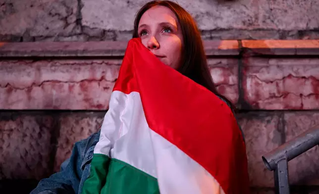 Woman reacts in the streets after the announcement of partial results of the Hungarian parliamentary election in Budapest, Hungary, Sunday, April 12, 2026. (AP Photo/Denes Erdos)