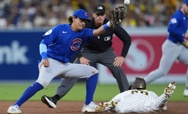 San Diego Padres' Bryce Johnson, below, safely steals second base as Chicago Cubs second baseman Nicky Lopez misses the catch during the fifth inning of a baseball game Tuesday, April 28, 2026, in San Diego. (AP Photo/Gregory Bull)