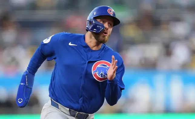 Chicago Cubs' Michael Busch rounds third base on his way to scoring from first base off a two-RBI double by Dansby Swanson during the second inning of a baseball game Tuesday, April 28, 2026, in San Diego. (AP Photo/Gregory Bull)