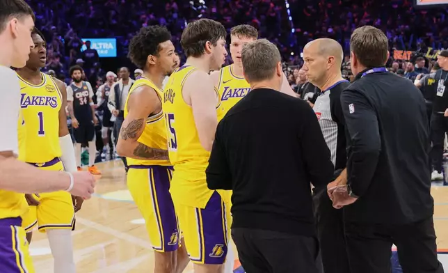 Los Angeles Lakers' Austin Reaves (15) and other Lakers players talk with referee John Goble, second from right, after the team's loss in Game 2 in a second-round NBA basketball playoffs series against the Oklahoma City Thunder Thursday, May 7, 2026, in Oklahoma City. (AP Photo/Nate Billings)