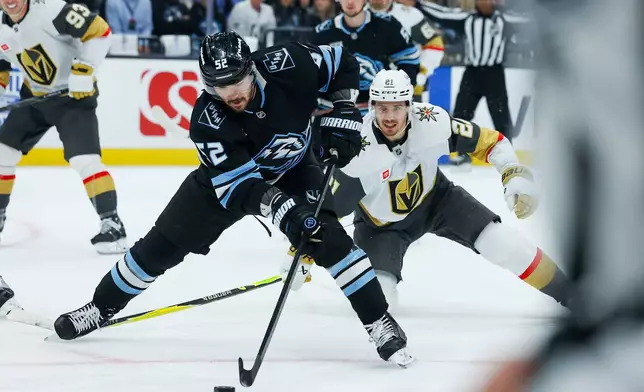 Utah Mammoth defenseman MacKenzie Weegar (52) controls the puck against Vegas Golden Knights center Brett Howden (21) during the first period of Game 6 in the first round of an NHL hockey Stanley Cup playoff series, Friday, May 1, 2026, in Salt Lake City. (AP Photo/Melissa Majchrzak)
